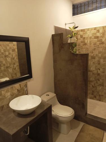 a bathroom with a toilet and a sink and a shower at Hotel Chicala salgar in Puerto Salgar