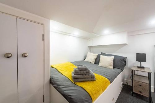 a bedroom with a bed with a yellow blanket at Quirky Studio in Central Reading in Reading