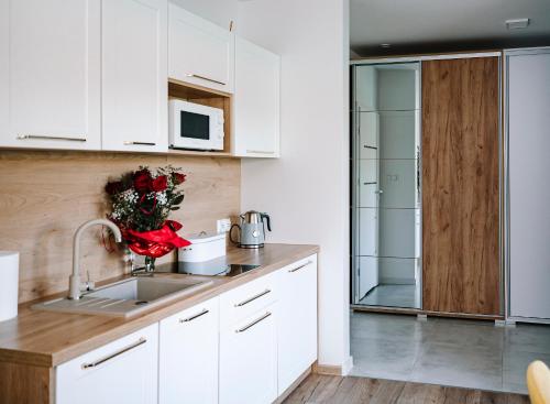 a kitchen with white cabinets and a sink at Apartament ZłotogórSKI Lądek-Zdrój in Lądek-Zdrój
