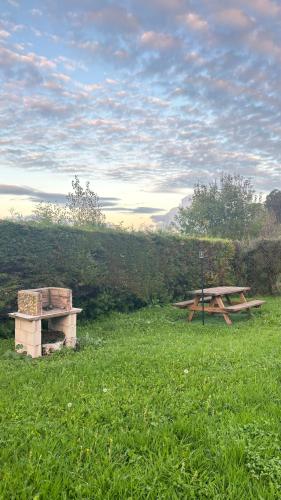 a picnic table and bench in a field of grass at Rural El Bosque in Entrambasaguas