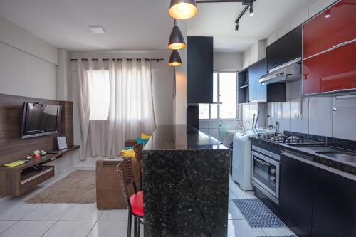 a kitchen with a black counter top in a room at Confortavel Apê - 5 min Parque Exposição Maringá in Sarandi
