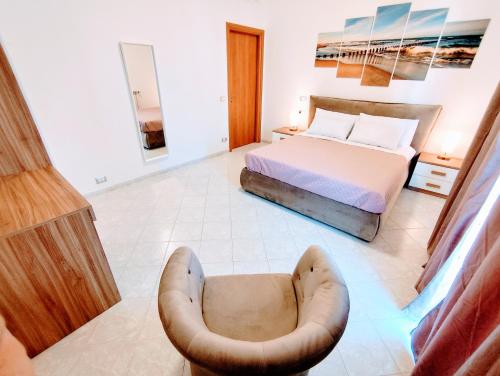 una camera da letto con un letto e una sedia di Apartment RSK by the sea a Lido di Ostia