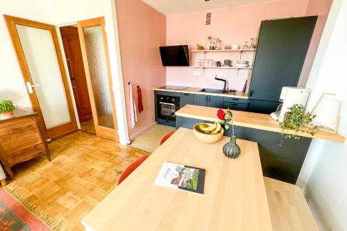 - une petite cuisine avec une table et un vase de fleurs dans l'établissement Rooftop VIEW - Elevator - Hypercenter, à Avignon