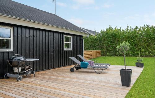 a wooden deck with a table and chairs on a house at Holiday Home Strandbakken Bogø By Iv in Bogø By