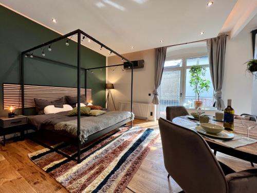 a bedroom with a canopy bed and a dining room at EDLER WOHNRAUM Luxuriöses Studio im Zentrum mit Balkon, Kaffeevollautomat, Klima & Parkplatz in Zwickau