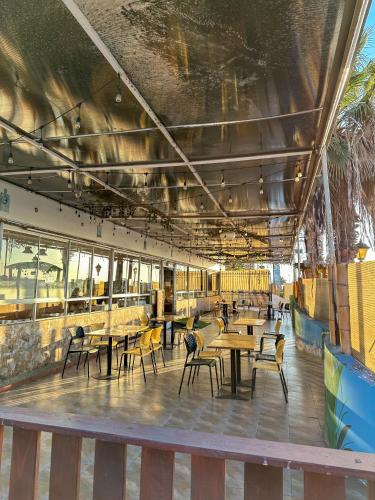 a dining room with tables and chairs and windows at Hotel & Spa Las Taguas in Arica