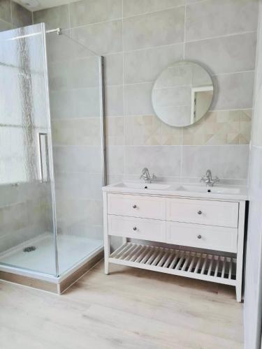 a bathroom with a shower and a sink and a mirror at Logements 6 pers à 15 minutes d Angers in Corné