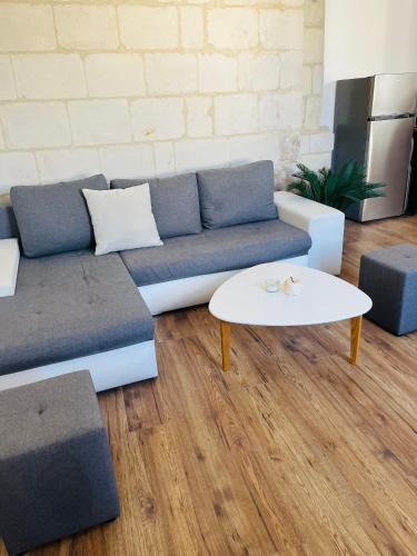 a living room with a couch and a table at Logements 6 pers à 15 minutes d Angers in Corné