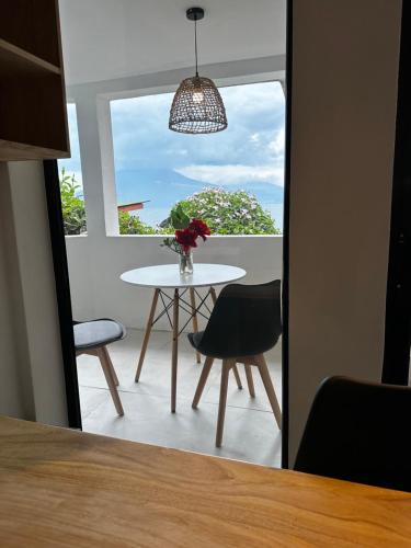 a table and chairs in a room with a window at Atitlan Sunset Lodge in Santa Cruz La Laguna