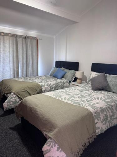 Un dormitorio con dos camas y una ventana. en Little Slice of Paradise, en Hat Head