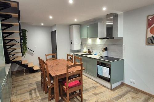 une cuisine avec une table en bois et une salle à manger dans l'établissement Chez Maude et Clément, à Mer