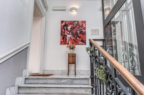 a painting hanging on a wall next to a stairway at Suite della Pigna in Rome