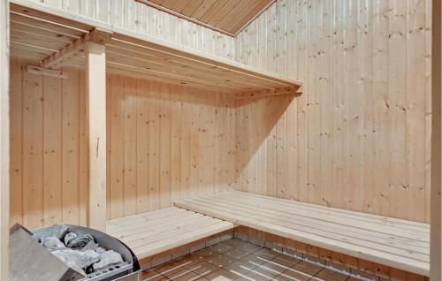 a wooden sauna with a bench and a trash can at Stunning Home In Spøttrup With Sauna in Vadum