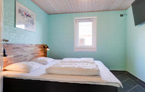 a large bed in a blue room with a window at Stunning Home In Spøttrup With Sauna in Vadum