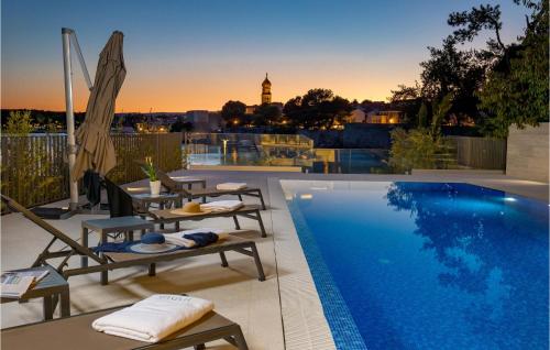 basen z leżakami obok budynku w obiekcie Lovely Apartment In Krk With Kitchen w Krku