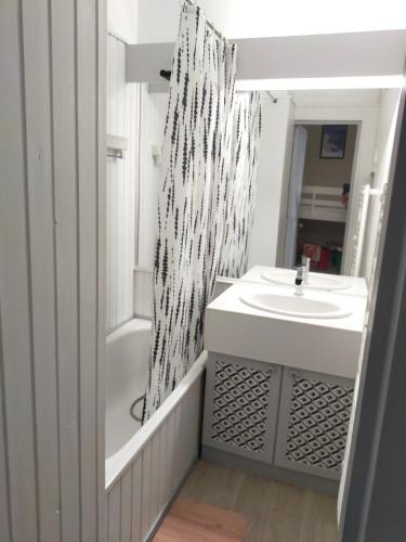 une salle de bain blanche avec un lavabo et un miroir dans l'établissement Studio 2 - Mont Dore face aux Thermes - Hyper-Centre, à Le Mont-Dore