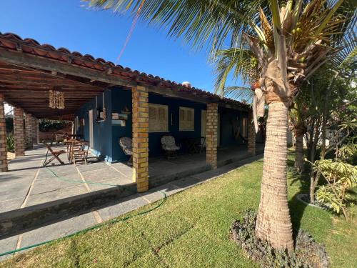 a house with a palm tree in the yard at Luar Da Barra in Barra Grande