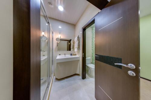 a bathroom with a shower and a toilet and a sink at Elbrus Hotel in Cheboksary
