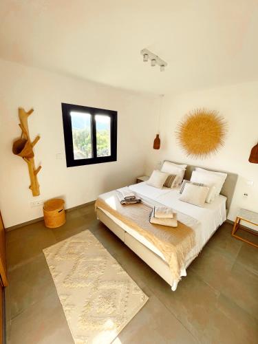 une chambre avec un grand lit blanc et une fenêtre dans l'établissement Casa olival, à Oletta