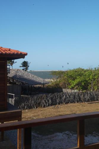 a fence next to a house with a rock wall at Canto do Mar - Atins - Lençóis Maranhenses in Atins