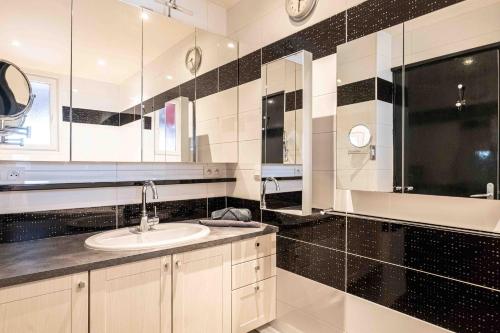 une salle de bain avec un lavabo et un miroir dans l'établissement Le Sommeiller, à Annecy