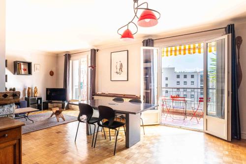 un salon avec une table et des chaises et un balcon dans l'établissement Le Sommeiller, à Annecy