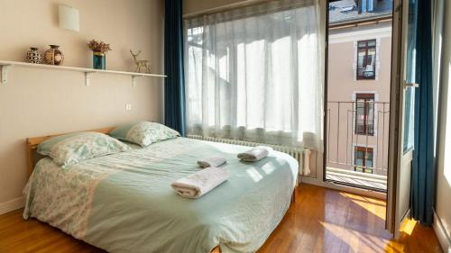 une chambre avec un lit et une grande fenêtre dans l'établissement Annecy cœur de ville - Appartement balcon, à Annecy
