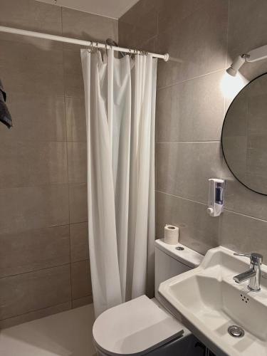 ein Badezimmer mit einem weißen Duschvorhang und einem Waschbecken in der Unterkunft Can Setmanes by CozyCatalonia in Blanes