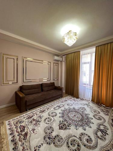 a living room with a couch and a large rug at Жан Айсулу in Türkistan