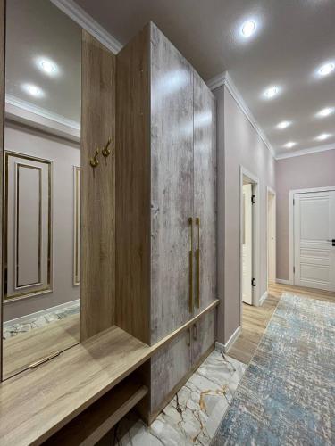a bathroom with a large wooden cabinet in a room at Жан Айсулу in Türkistan