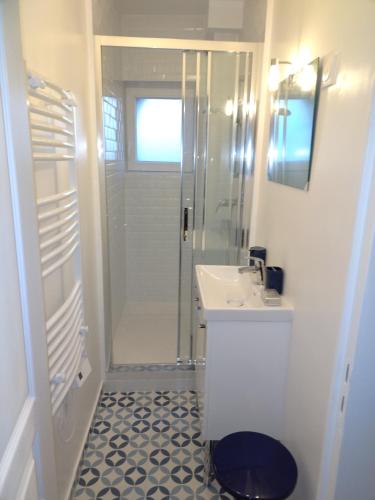 une salle de bain blanche avec une douche et un lavabo dans l'établissement Le vintage, 10 min de Disney et 30 min de Paris - 50 m gare, à Esbly
