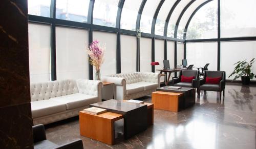 a living room with couches and tables and windows at J&A Classic Hotel in Lima