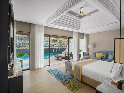 a bedroom with a king sized bed and a living room at InterContinental Phuket Resort by IHG in Kamala Beach