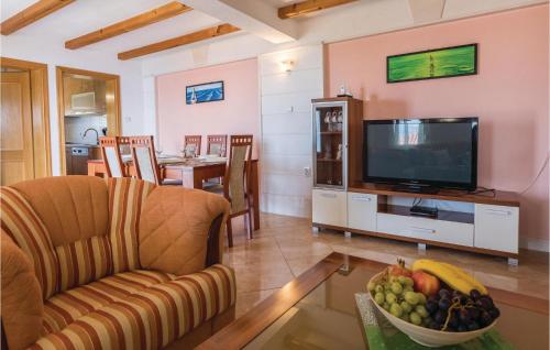 a living room with a television and a bowl of fruit at Two-Bedroom Apartment In Komarna in Klek