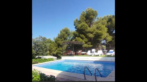 een zwembad in een tuin met een prieel bij Casa Rural MONTE VERDE in Illana