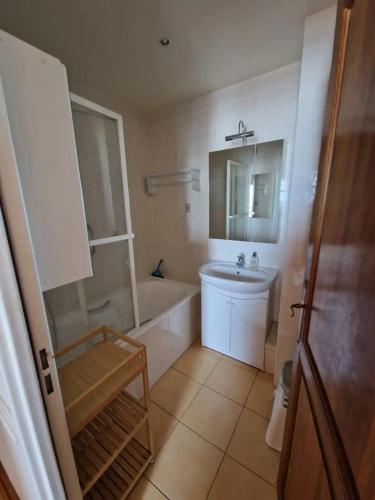 une salle de bain avec une baignoire, un lavabo et des toilettes dans l'établissement Appartement vue mer, à Cabourg