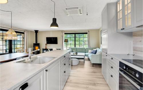 a kitchen with a sink and a living room at Nice Home In Hvide Sande With Sauna in Bjerregård