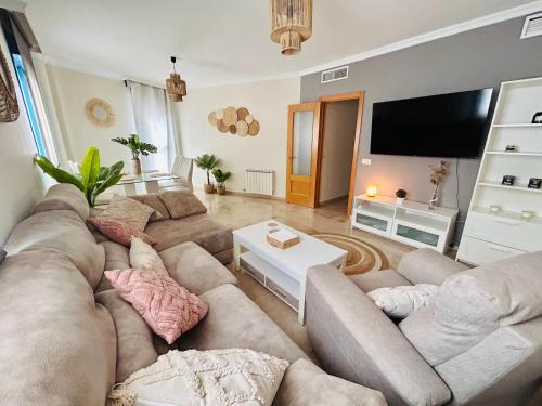 Una sala de estar con un sofá y un televisor de pantalla plana. en La Morada de Eva, en Ronda