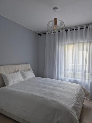 ヨハネスブルグにあるCorporate Luxury - Sandton, Rivoniaの大きな白いベッドと窓のある寝室