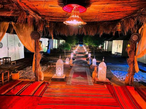 a long aisle with lanterns in a pavilion at Desert camp camel & sandboarding in Merzouga