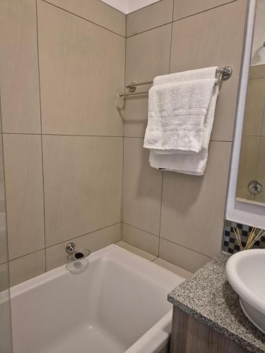 ヨハネスブルグにあるCorporate Luxury - Sandton, Rivoniaの白い浴槽と洗面台のあるバスルーム