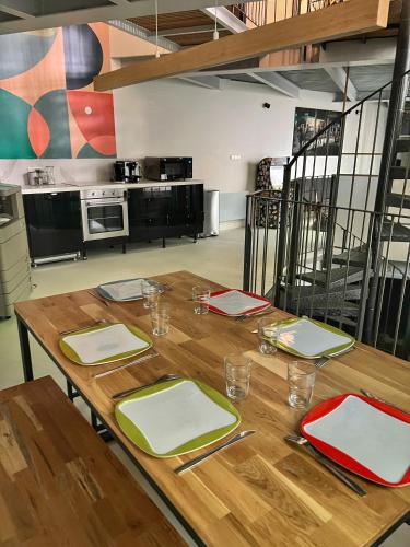 une table en bois avec des assiettes et des serviettes en haut de celle-ci dans l'établissement Rooms Buttes Chaumont Chambres Buttes Chaumont, à Paris