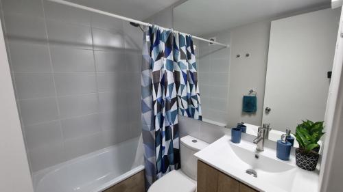 une salle de bain avec un lavabo, des toilettes et une douche dans l'établissement Apartamento a pasos del Mar, à La Serena