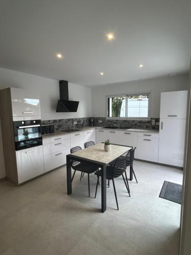 une cuisine avec une table et des chaises dans l'établissement maison rue neuve, à Plouay