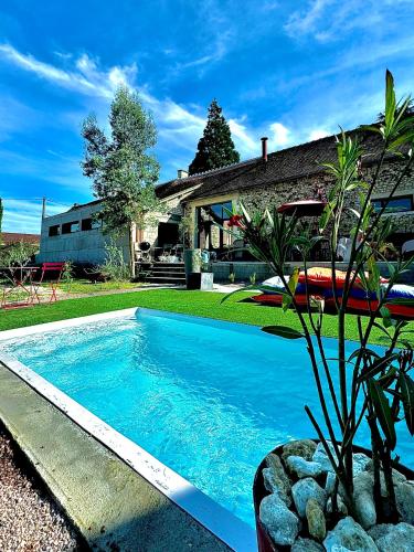 a swimming pool in a yard next to a house at Maison ancienne moderne et design - 6 chambres 6 sdb - avec piscine et grand parc in Buxeuil