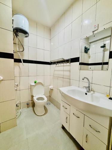 a bathroom with a toilet and a sink at KBH by Royal Village in Singida