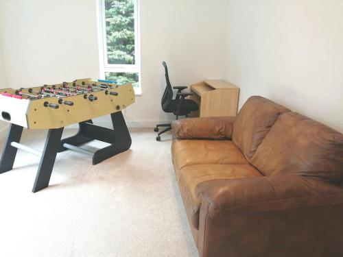 a living room with a couch and a table at The Highlands - 5 bed 5 bath - Huge Sociable House in Exning
