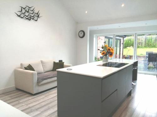 a kitchen and living room with a couch and a table at The Highlands - 5 bed 5 bath - Huge Sociable House in Exning