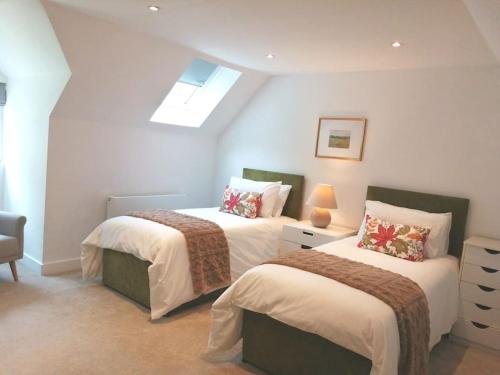 a bedroom with two beds and a skylight at The Highlands - 5 bed 5 bath - Huge Sociable House in Exning