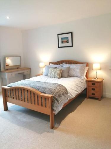 a bedroom with a bed with two night stands and two lamps at The Highlands - 5 bed 5 bath - Huge Sociable House in Exning